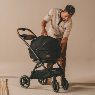 man attaching pet carrier to stroller frame