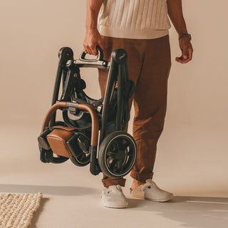 man carrying small pet stroller frame